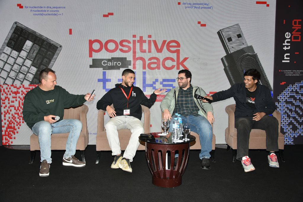 Four people in armchairs talking on stage in front of the Cairo backdrop