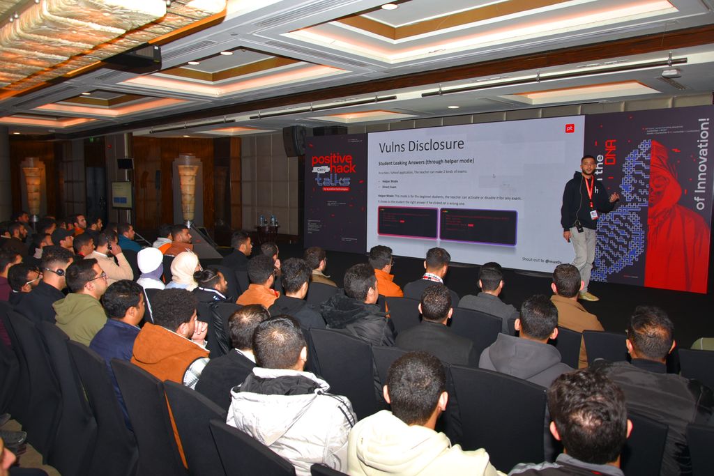A speaker presenting a slide on vulnerability disclosure to a full hall