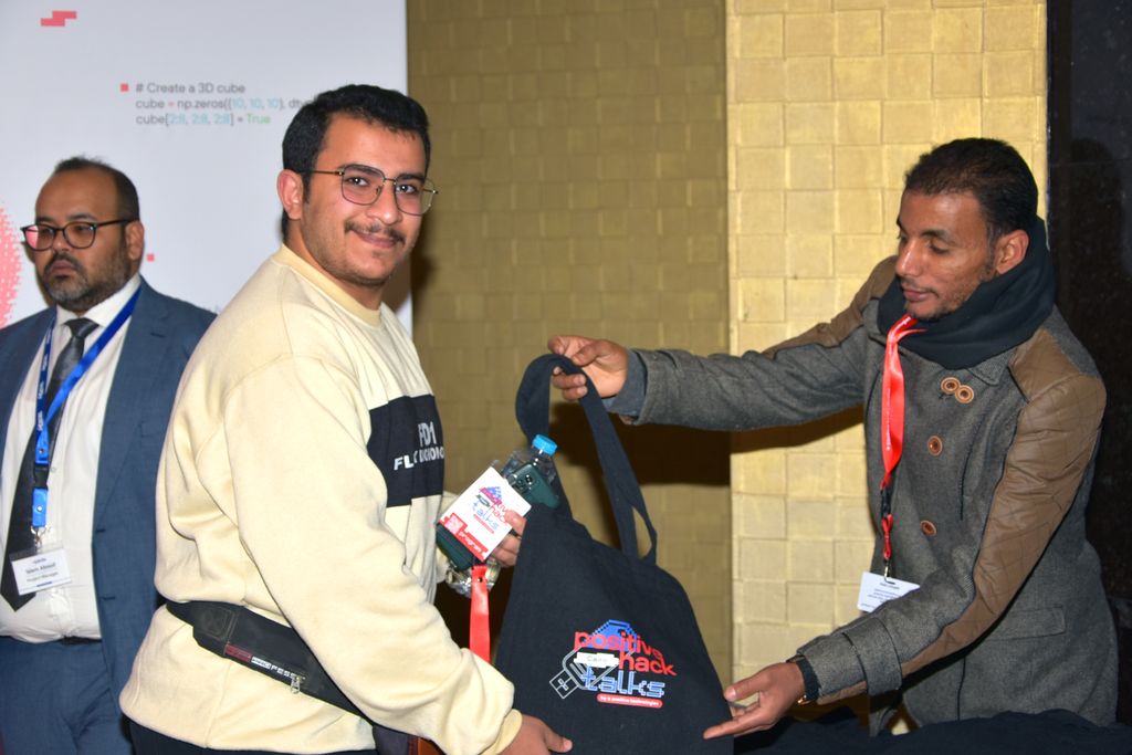 An attendee receiving a Positive Hack Talks tote bag