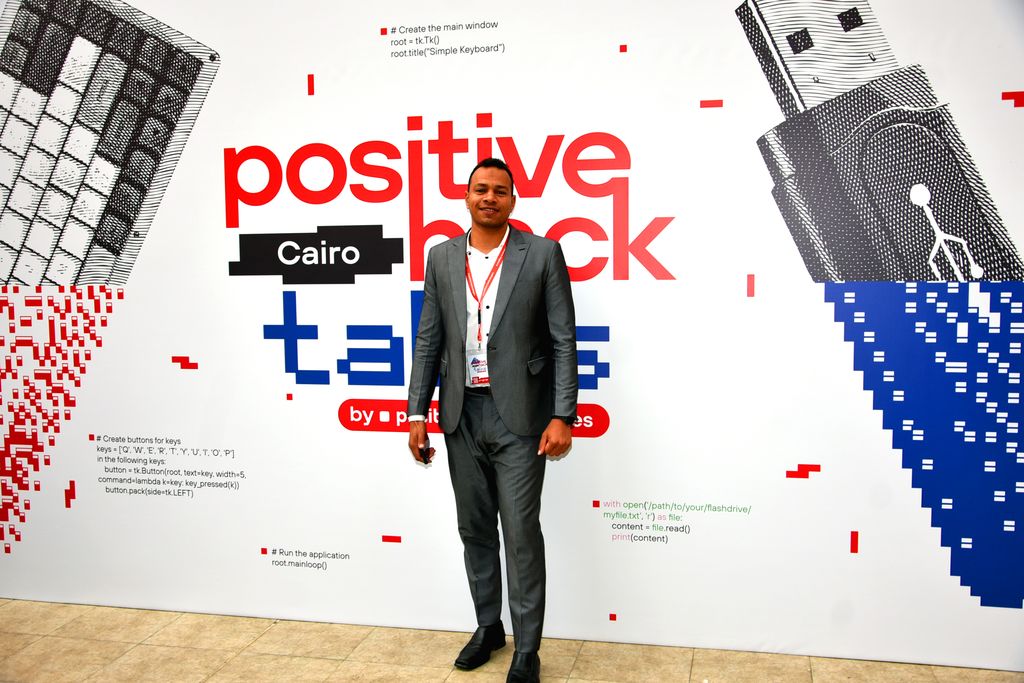 An attendee in front of the Positive Hack Talks Cairo backdrop