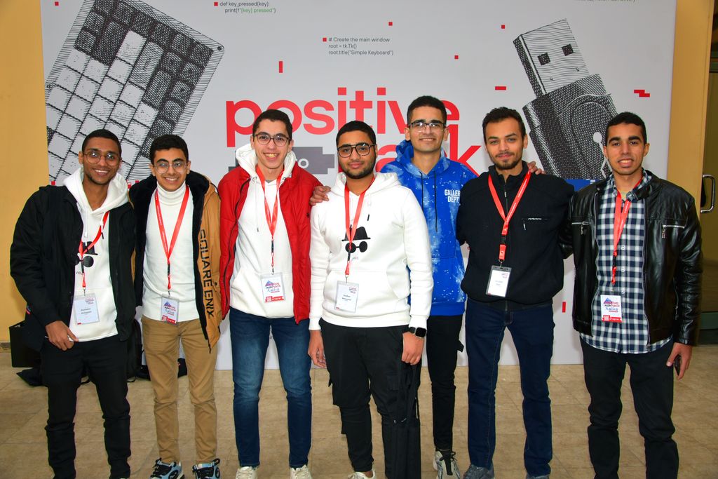 Seven attendees in front of the Positive Hack Talks Cairo backdrop