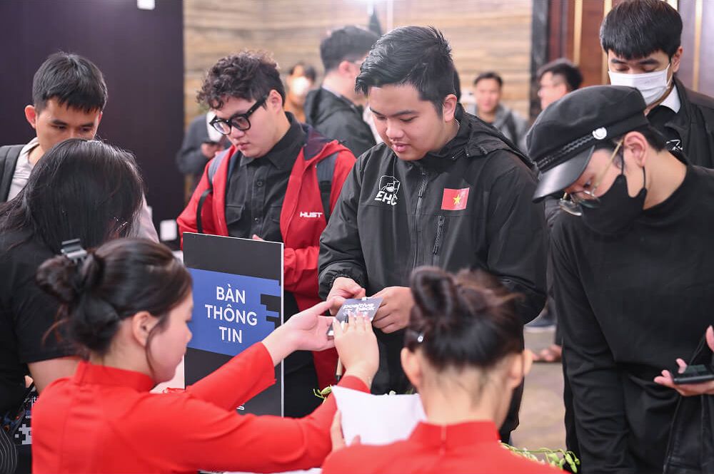 Attendees collect their badges at the information desk